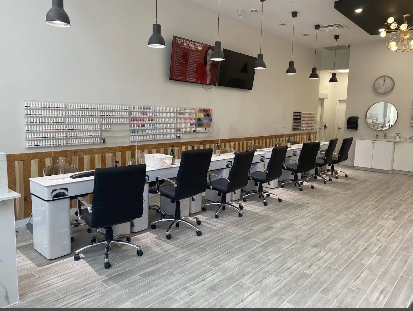 Manicure stations at Pedi N Nails Dundas East beside the wall of polish colours